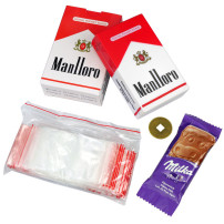 Kleines Händlerset: Waage, Glücksmünze, Milka-Schokolade und eine Packung wiederverschließbarer Beutel